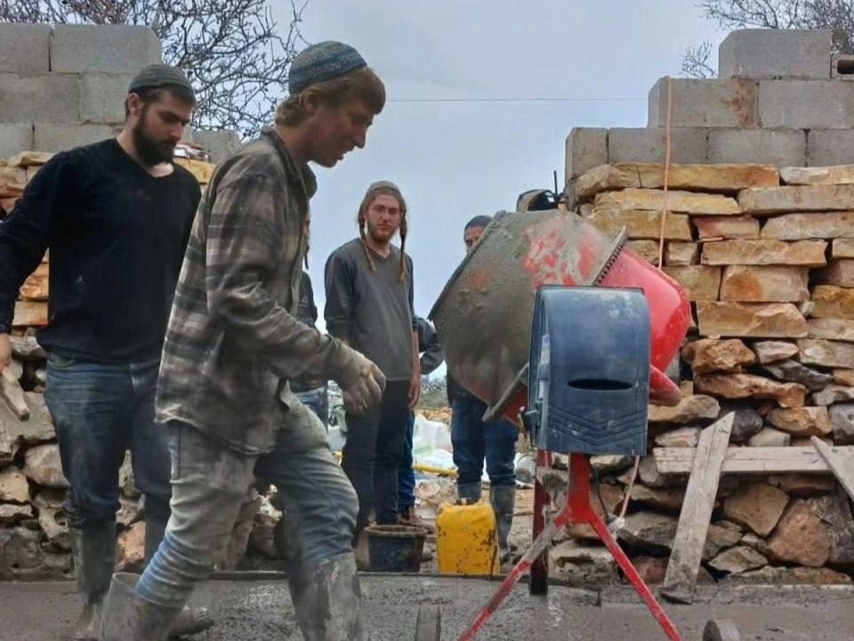 Un gruppo di giovani coloni al lavoro per avviare l'insediamento su un terreno agricolo palestinese